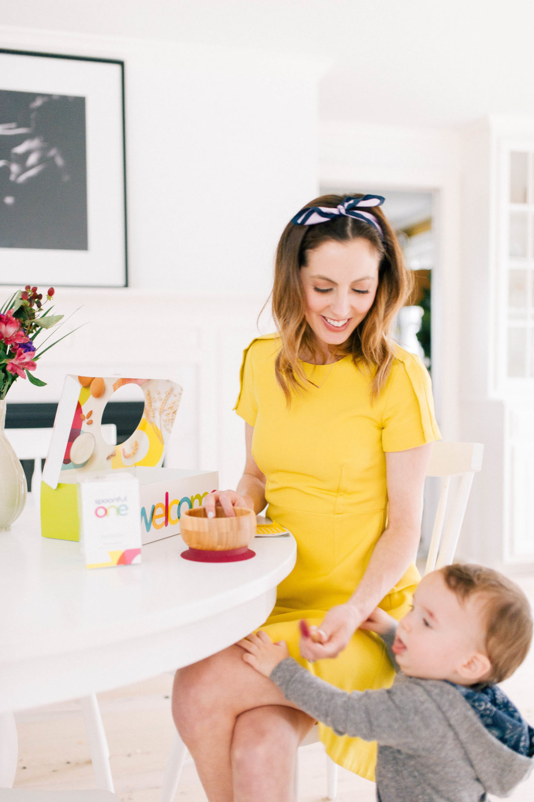 Eva Amurri Martino wears a yellow dress and sits in the kitchen of her Connecticut home as she feeds SpoonfulOne to her son Major
