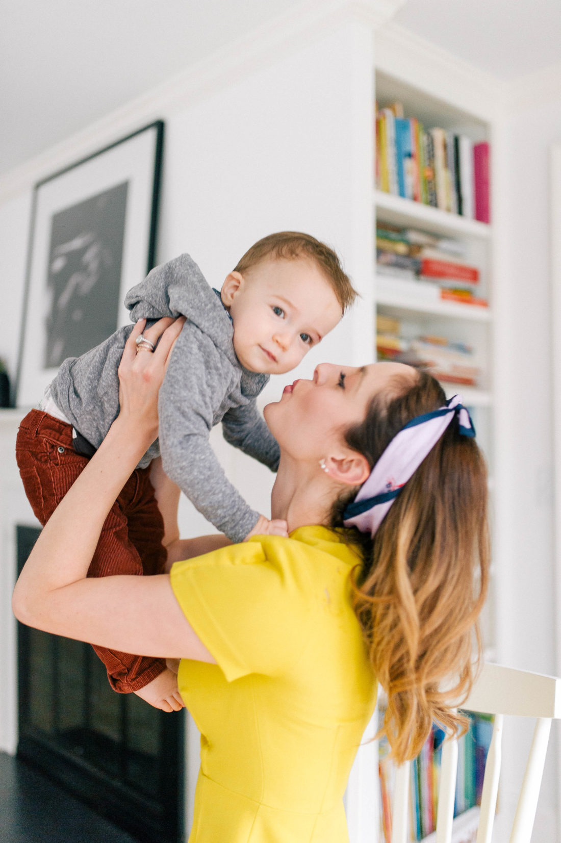 Eva Amurri Martino wears a yellow dress and lifts son Major up in her arms to kiss him