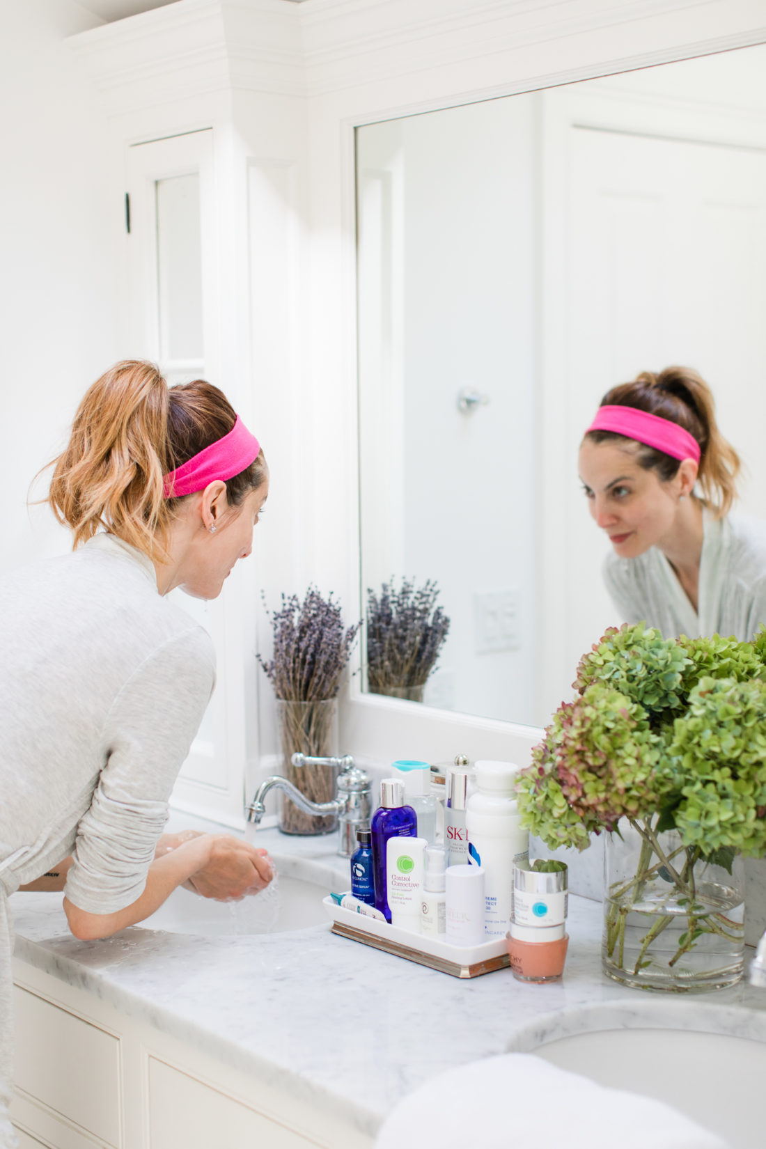 Eva Amurri Martino rinses off the face wash during her skin care routine in the bathroom of her Connecticut home