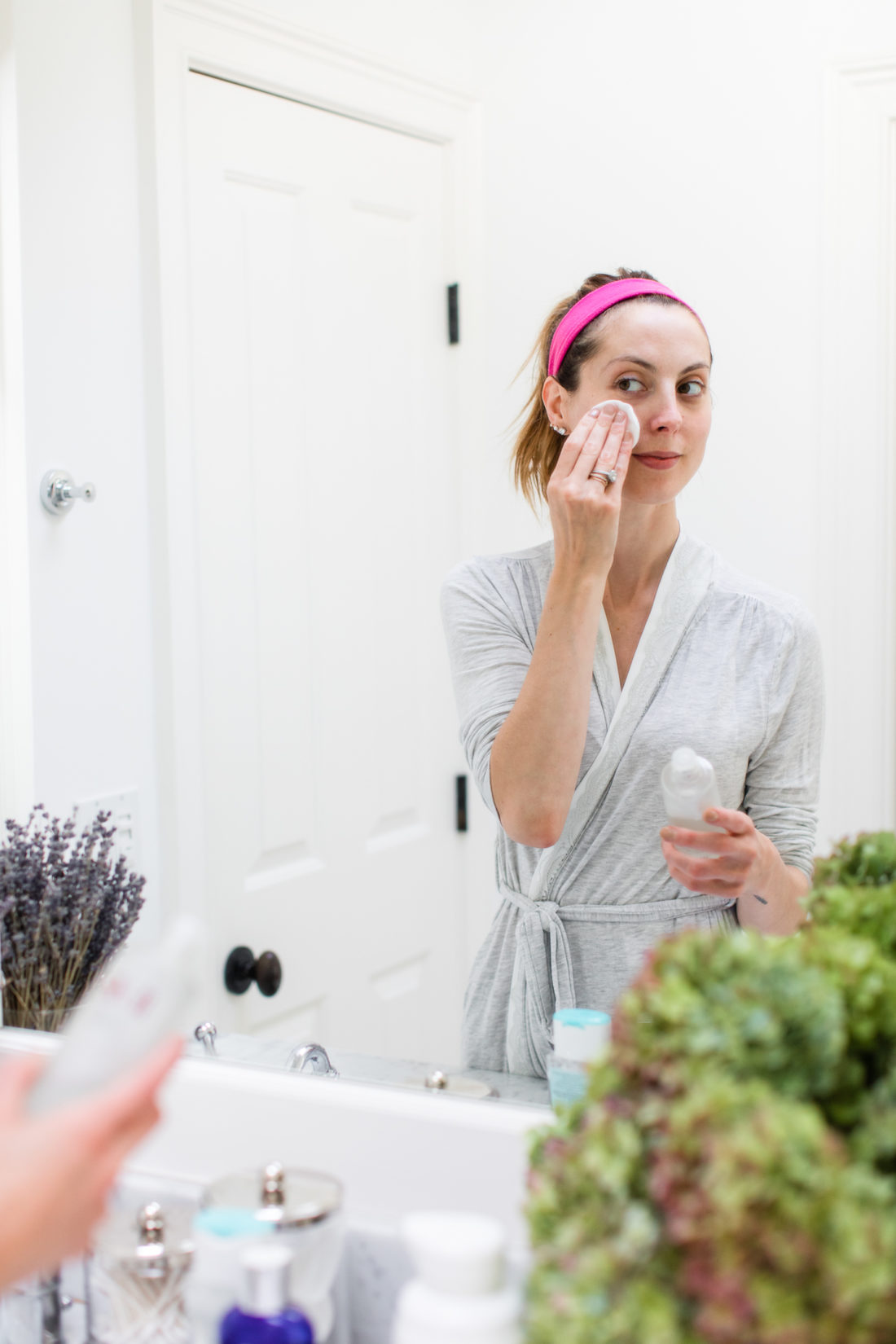 Eva Amurri Martino presses SKII facial treatment essence gently in to her skin using a cotton pad