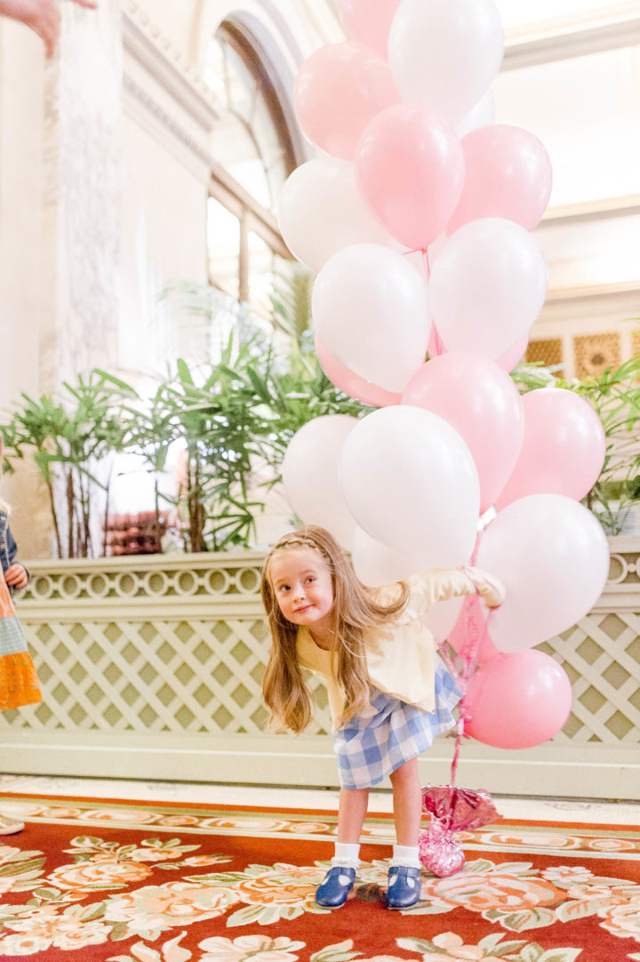 Eva Amurri Martino's daughter Marlowe carries pink and white balloons while walking through the iconic Plaza Hotel