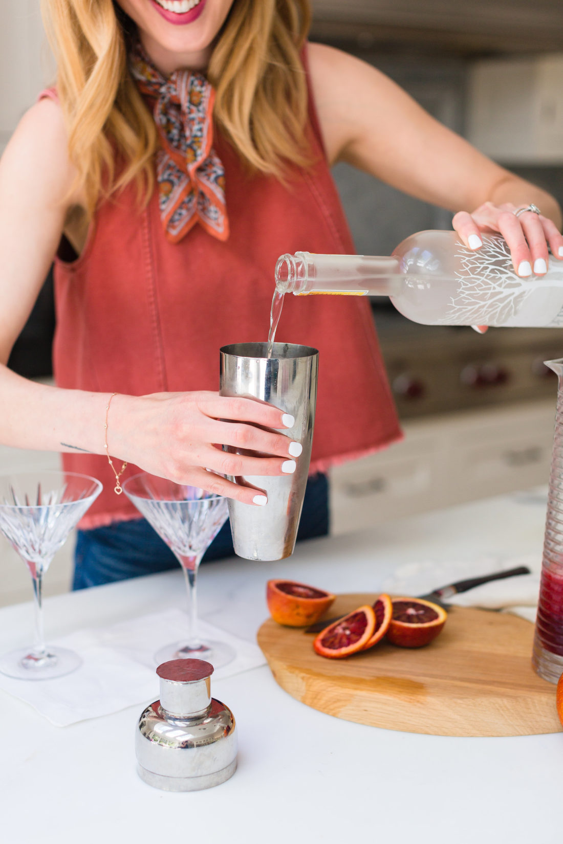 Eva Amurri Martino pours vodka in to a cocktail shaker to make blood orange and ginger martinis
