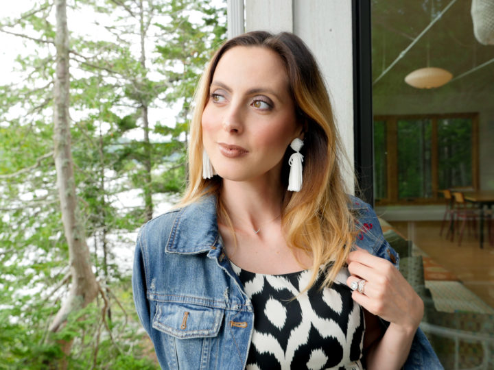 Eva Amurri Martino wears a geometric printed dress with a flare of pink and a denim jacket and white tassel earrings in Bar Harbor, ME.