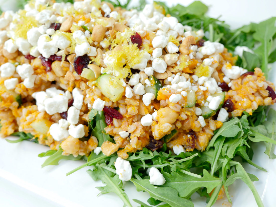 Happily Eva After Autumn Farro Salad with Sweet Potato, Cucumber, Chickpeas, cranberries, goat cheese, cashews, arugula, and lemon zest phtographed in a marble kitchen 