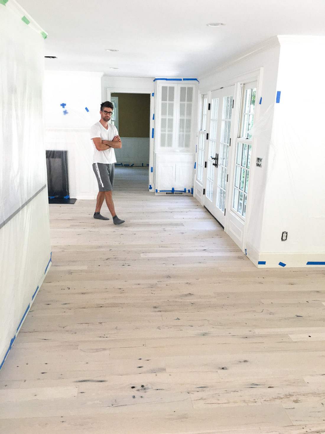 Kyle Martino walking on refinished light wood floors in his house in Connecticut