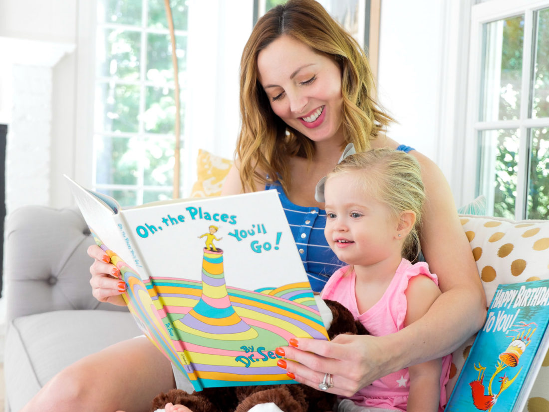 Eva Amurri Martino of the Happily Eva After blog, with her two year old daughter Marlowe, sitting in her bright and modern family room reading Dr. Seuss books on the couch