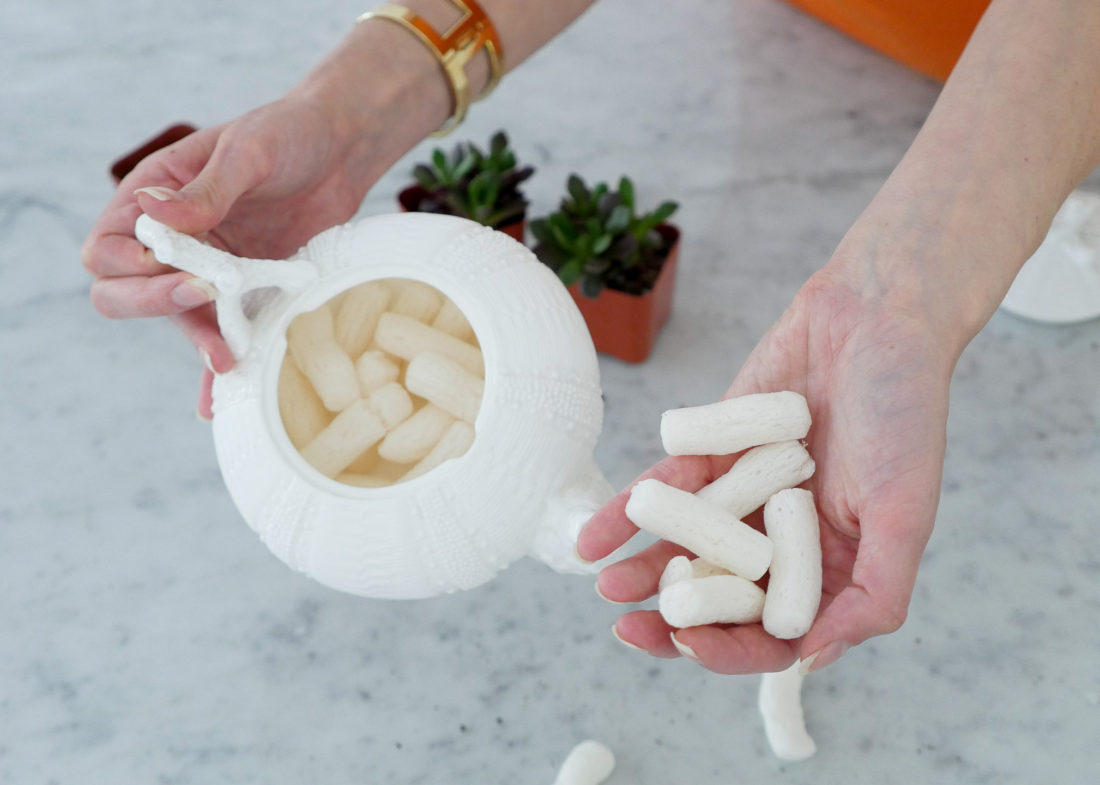 Eva Amurri Martino wearing a gold bracelet watch, showing how to craft DIY Teacup Planters on the Happily Eva After blog using a pebbled porcelain tea pot and mini succulents