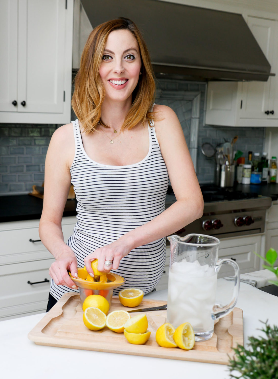 Eva Amurri Martino of lifestyle blog Happily Eva After squeezing lemons in her kitchen to make a hydrating laborade for her Home Birth