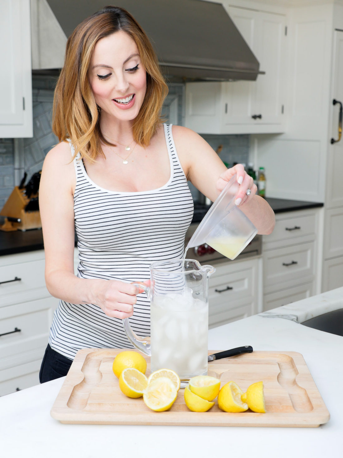 Eva Amurri Martino of lifestyle blog Happily Eva After squeezing lemons in her kitchen to make a hydrating laborade for her Home Birth
