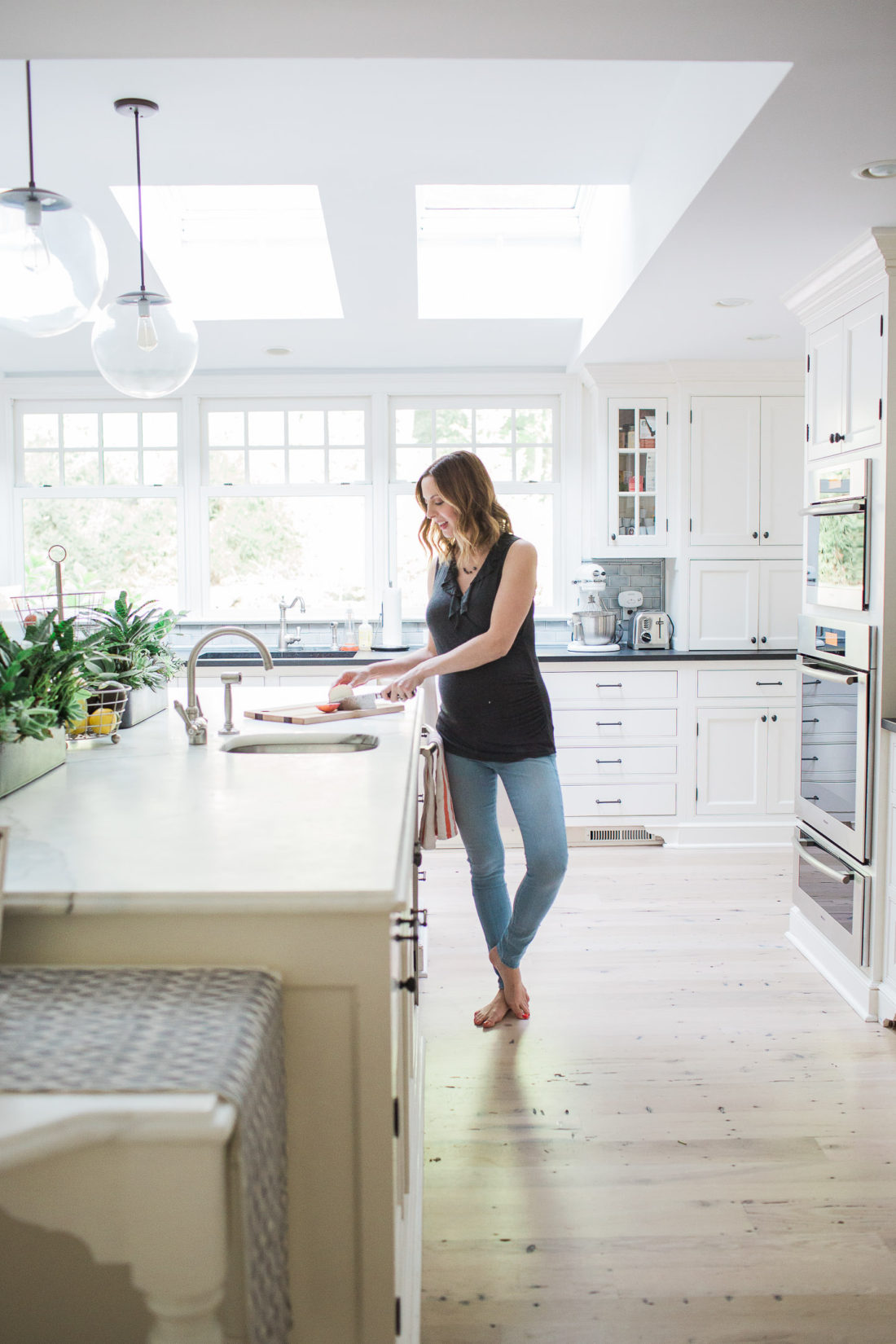 Eva Amurri Martino of lifestyle blog Happily Eva After in her white and bright kitchen in her connecticut home