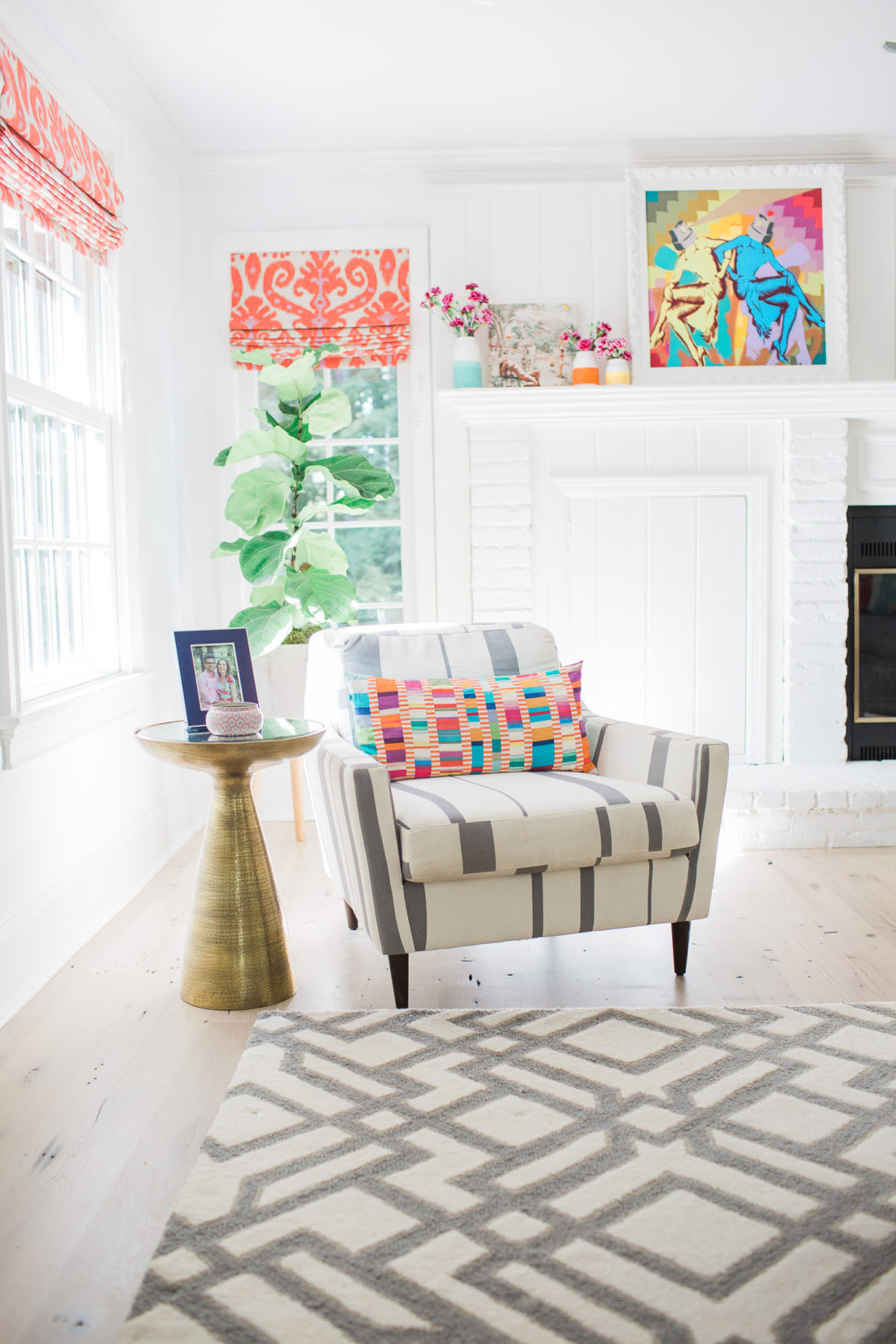A reading nook in the family room of eva amurri martino's connecticut home, splashes of pattern and orange and magenta custom ikat roman shades