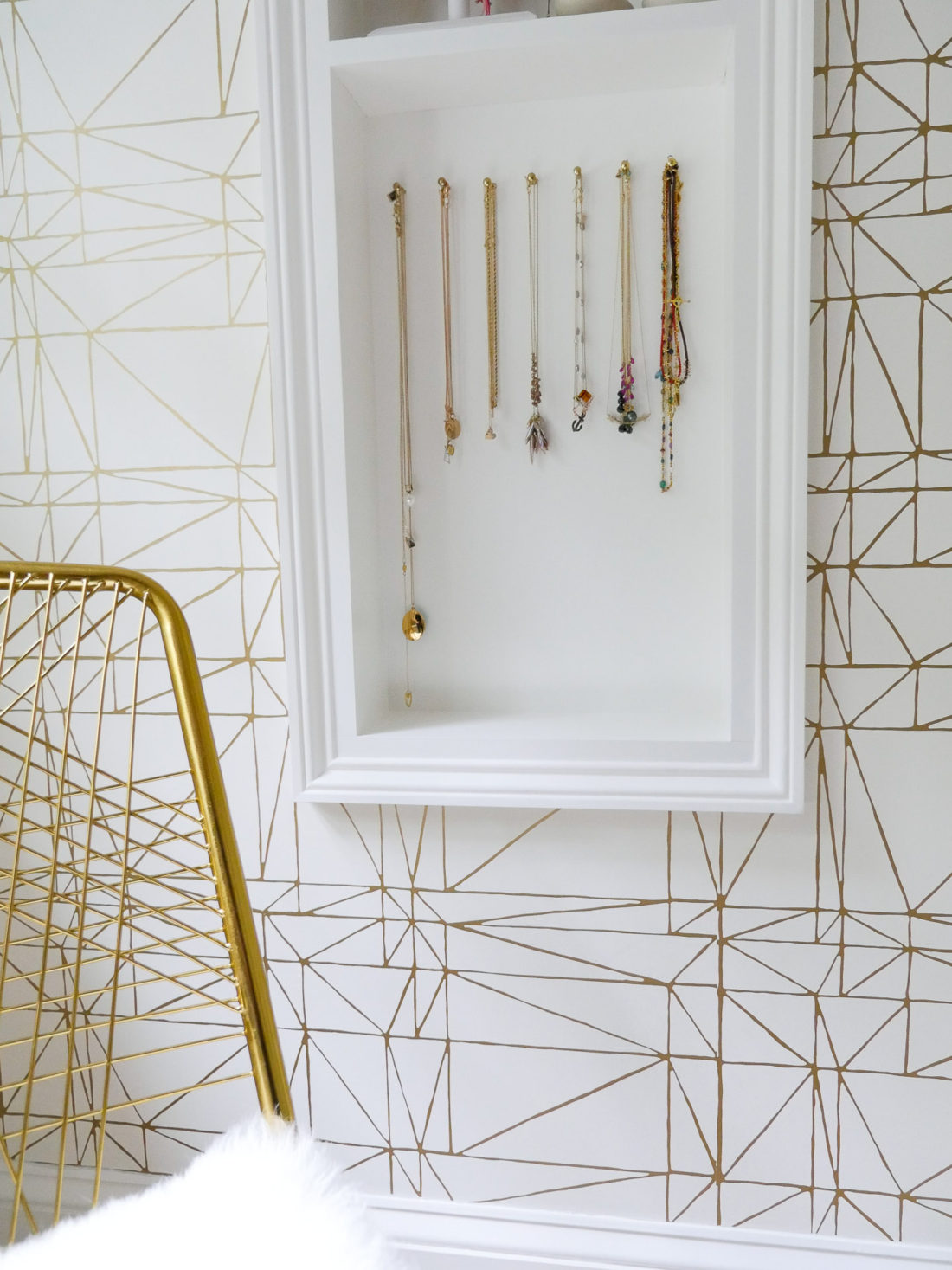 A close up of the necklace display in Eva Amurri Martino's glam room in her connecticut home featuring various gold necklaces