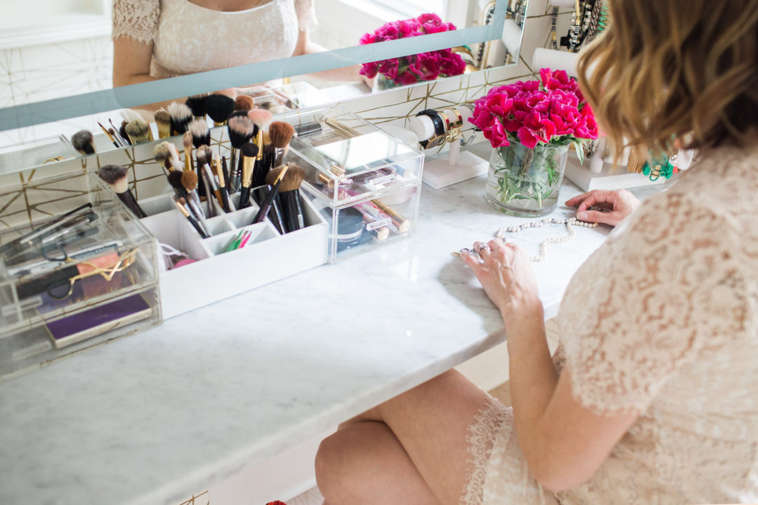 Eva Amurri Martino of lifestyle and motherhood blog happily eva after selects two pearl necklaces to wear from her makeup display in her glam room 