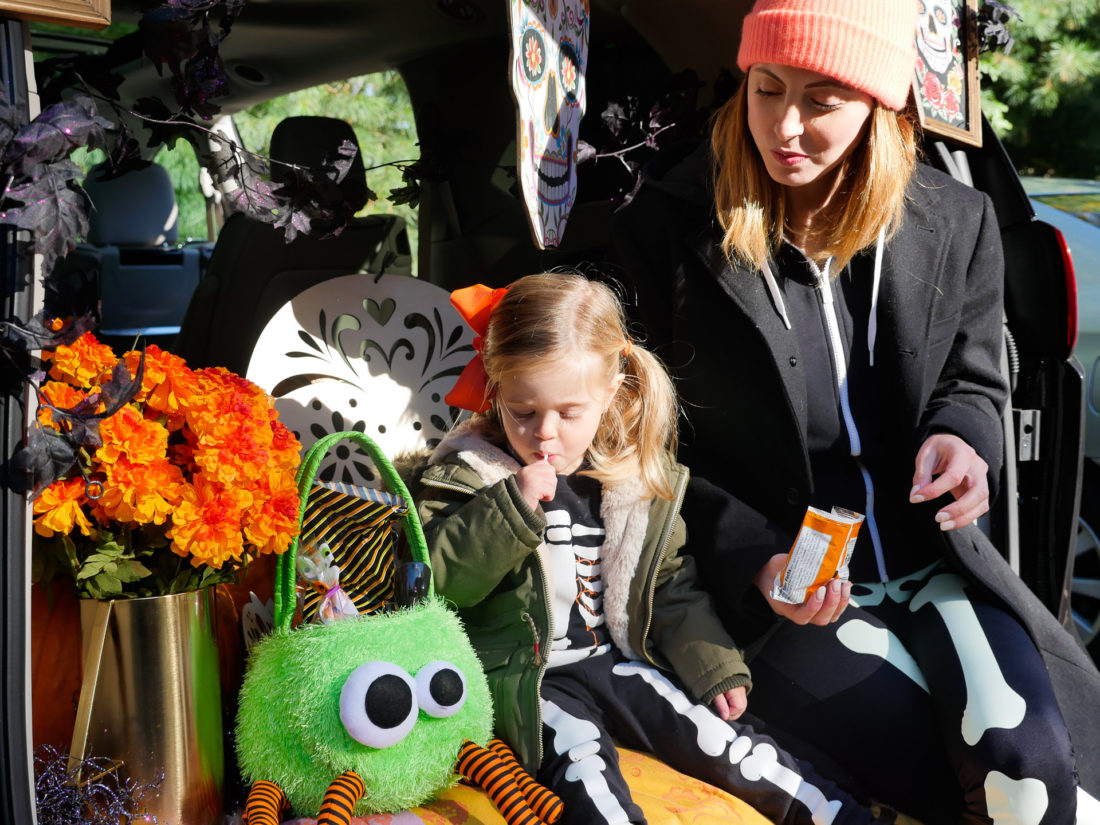 Marlowe Martino eating a snack in the decorated trunk at her school's Trunk Or Treat party