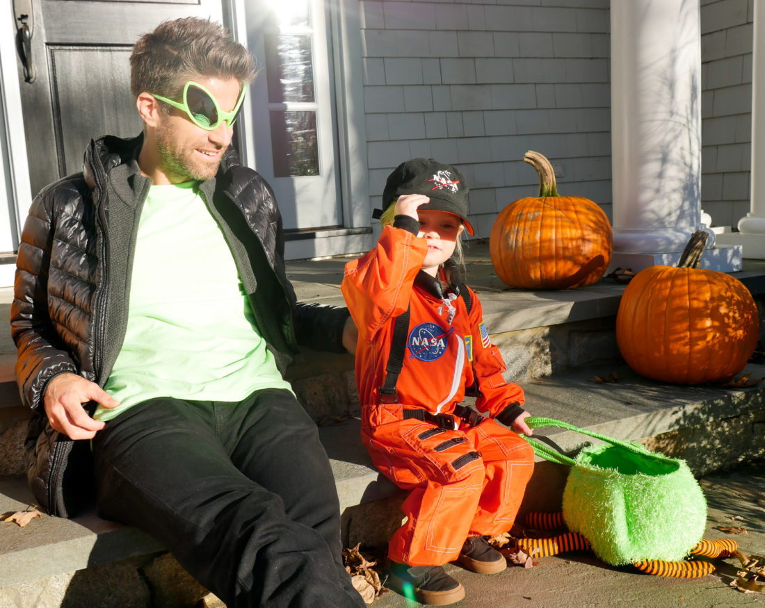 Kyle Martino and Marlowe Martino, sitting on the steps of their Connecticut home dressed as an Alien and an Astronaut for Halloween