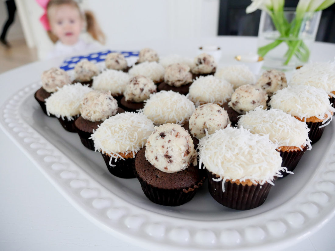 a close up of vanilla and chocolate cupcakes on a white tray