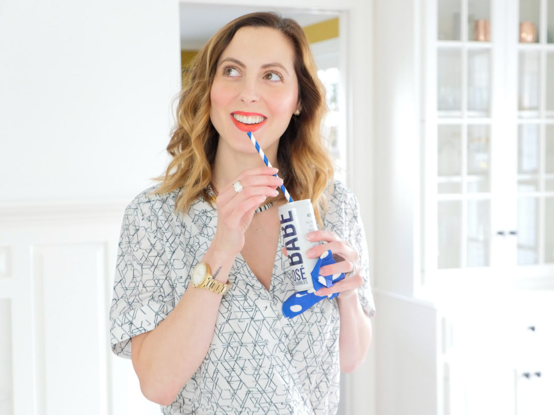 Eva Amurri Martino wearing a black and white jumpsuit and red lipstick drinking Babe Rose with Bubbles