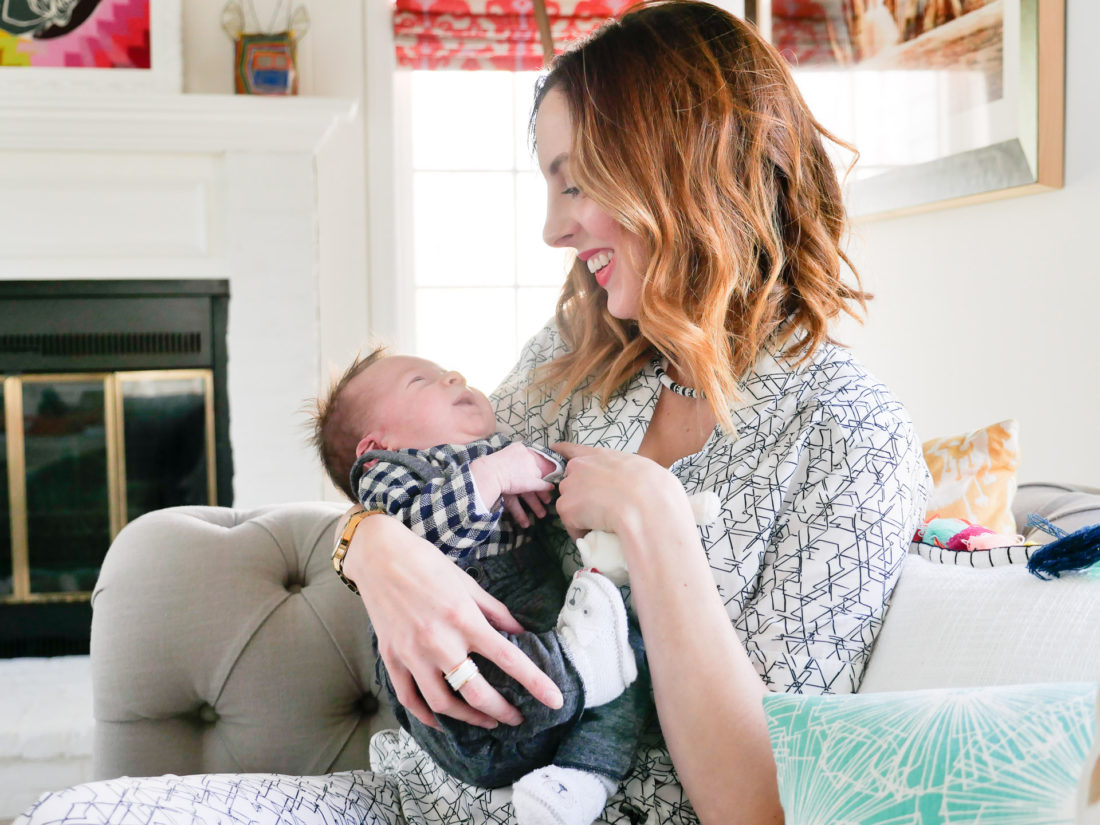 Eva amurri Martino of lifestyle and motherhood blog Happily Eva After, holding newborn son Major James at his Sip And See at home in Connecticut