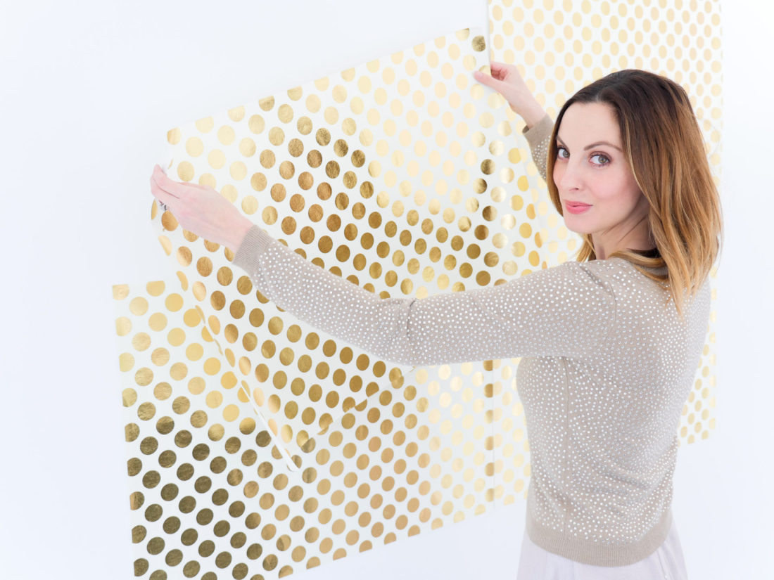 Eva Amurri Martino of lifestyle and motherhood blog Happily Eva After sets up a photo backdrop for her DIY Holiday Photo Place Cards project using the Instax mini 70