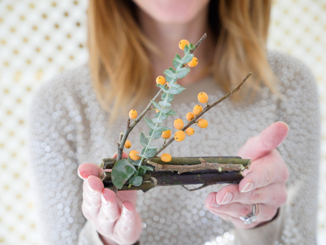 Eva Amurri Martino wearing a tan rhinestock embellished sweater, constructing her DIY Holiday Photo Frame Placecards using the Instax mini 70