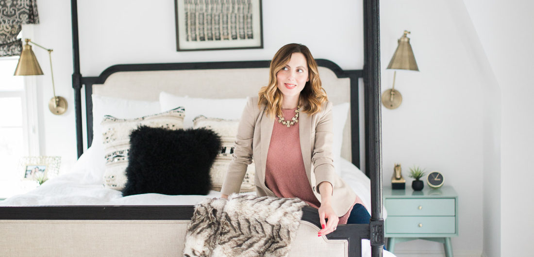 Eva Amurri Martino of lifestyle and motherhood blog Happily Eva After poses in her black, white, and brass master bedroom in Connecticut