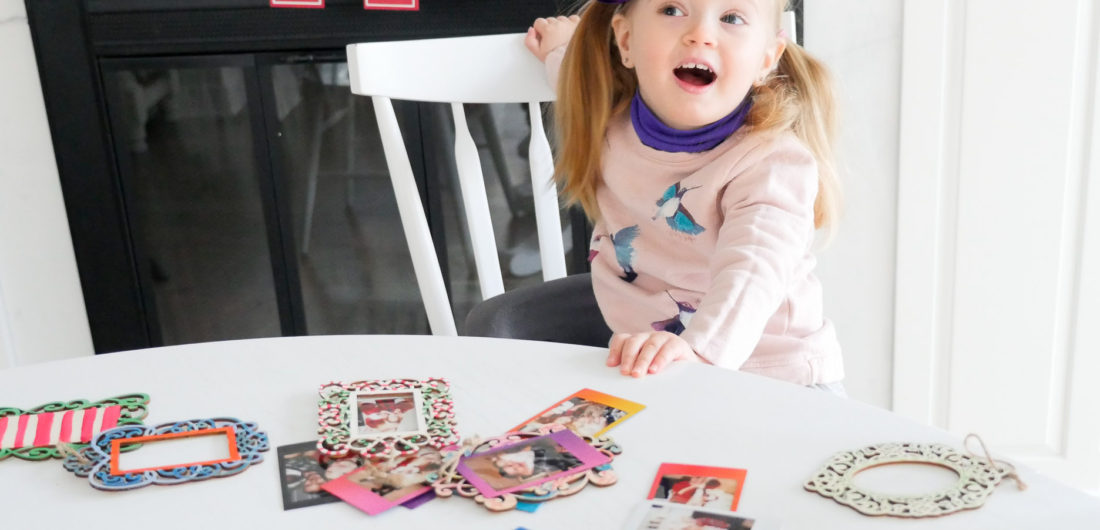 Marlowe Martino crafts Holiday photo ornaments at the kitchen table using Instax Mini 70 instant film
