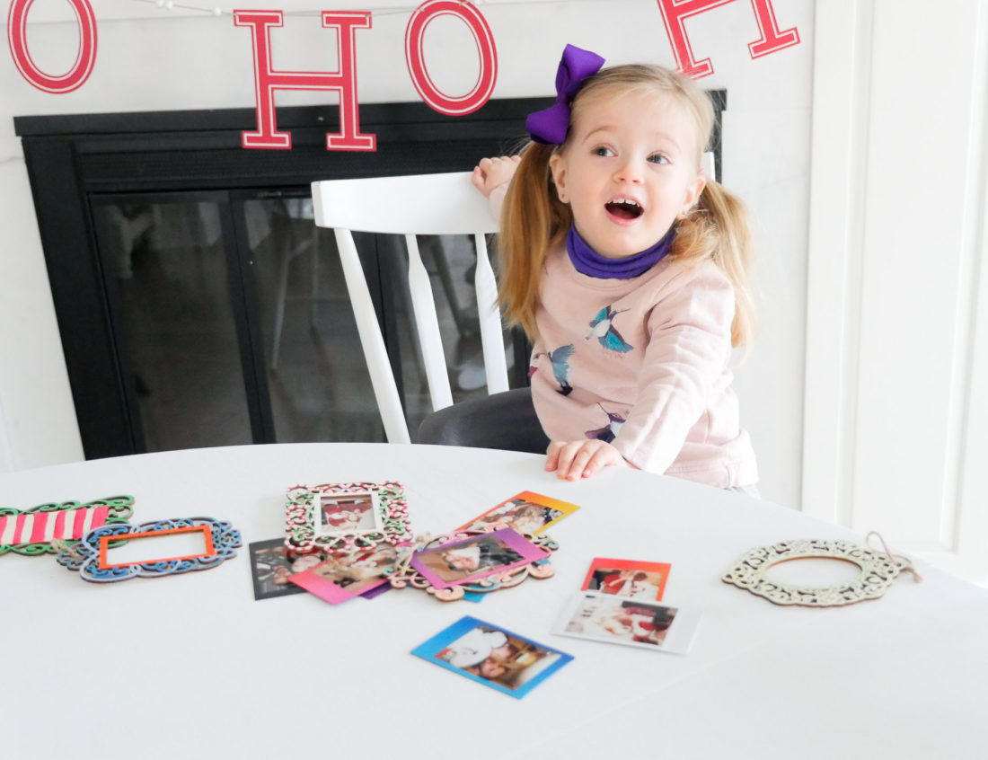 Marlowe Martino crafts Holiday photo ornaments at the kitchen table using Instax Mini 70 instant film