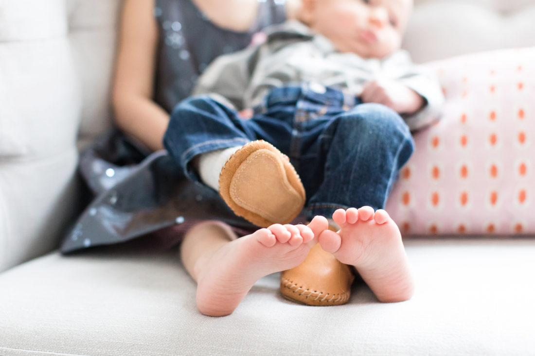 A close up of Marlowe and Major's feet as they sit together on the couch