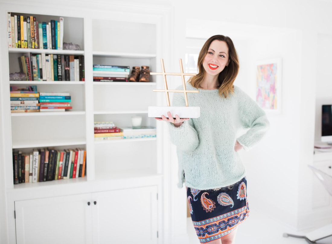 Eva Amurri Martino holds up a marble and brass Hashtag sculpture in the Happily Eva After studio