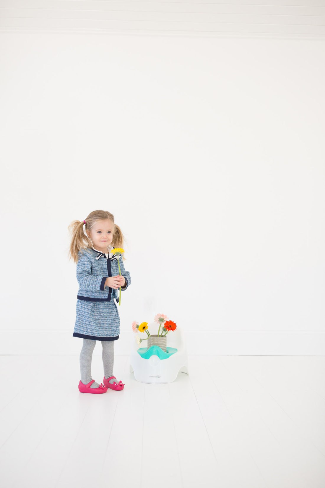 Marlowe Martino wears a tweed suit and pink kitty shoes and stands by her potty