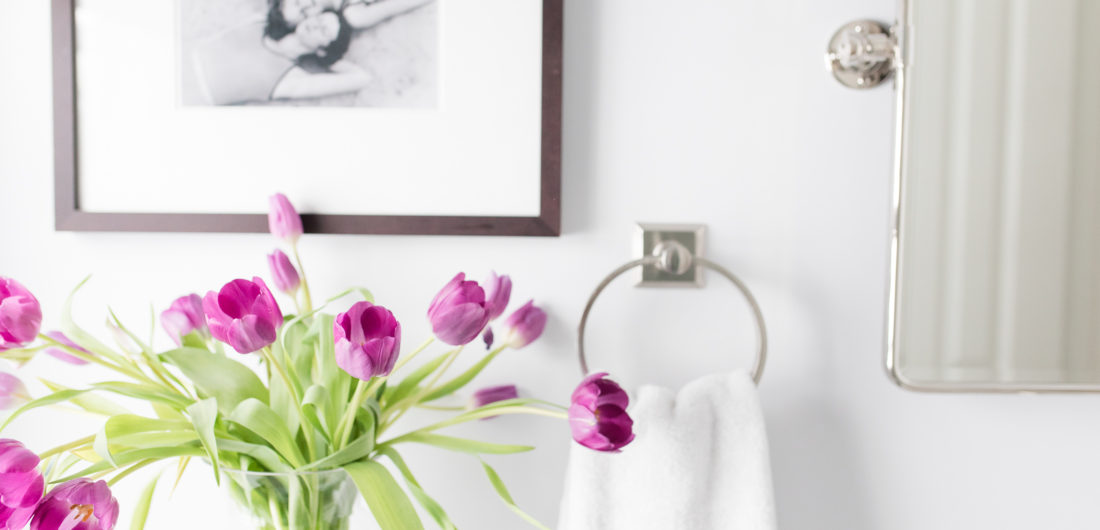 A detail of purple tulips in the bright white guest bathroom of Eva Amurri Martino's Connecticut home
