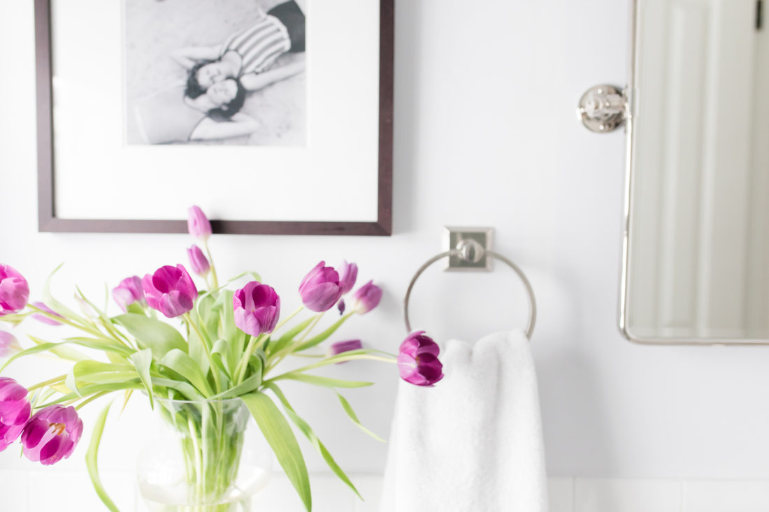 A detail of purple tulips in the bright white guest bathroom of Eva Amurri Martino's Connecticut home