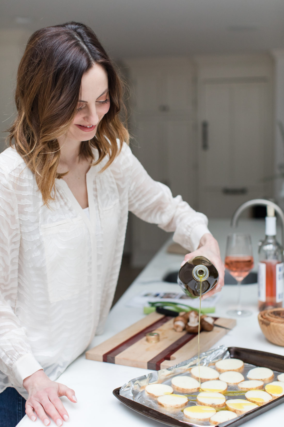 Eva Amurri Martino drizzles olive oil over sliced potatoes