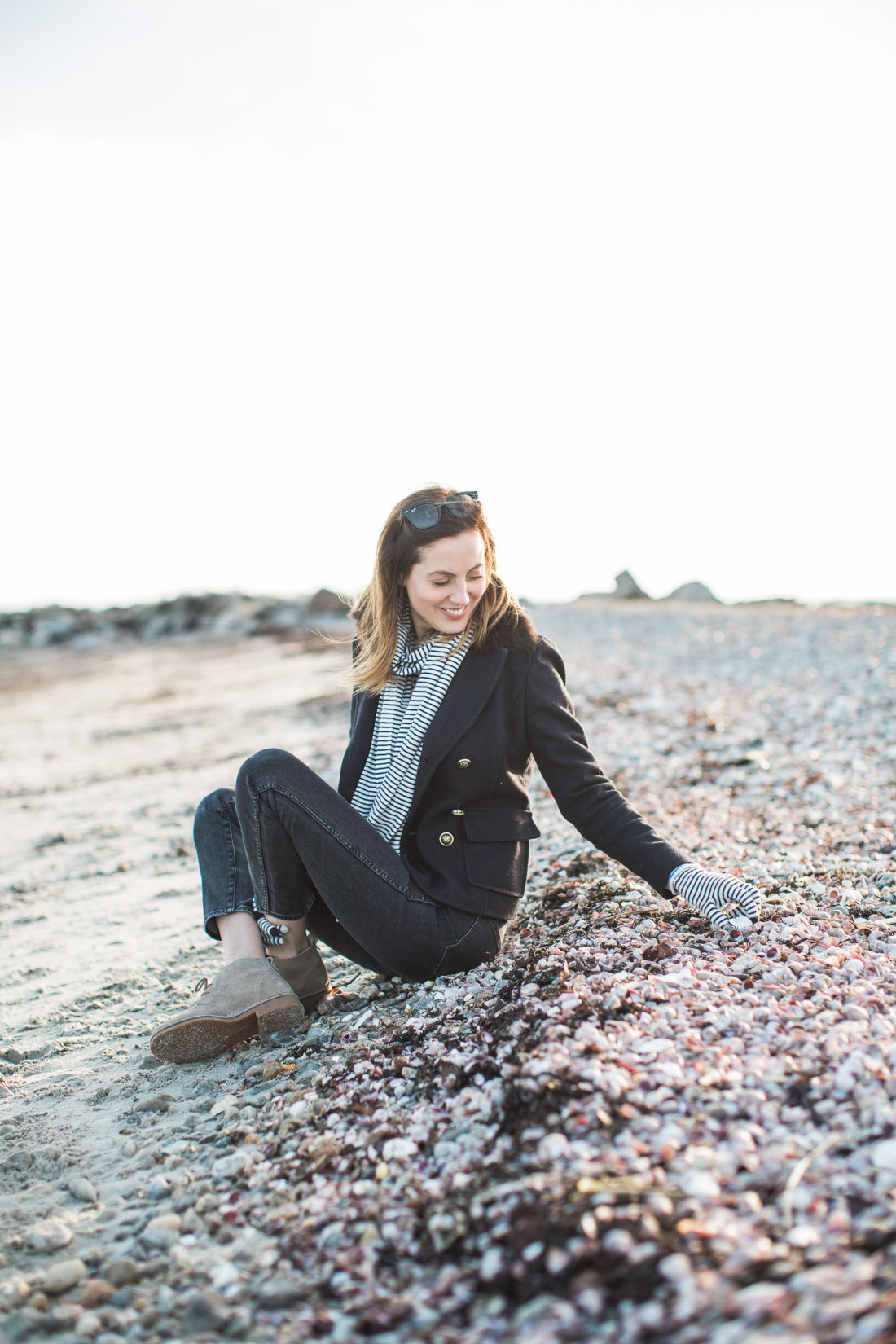 Eva Amurri Martino sits on the sand and picks up rocks in the winter on Compo Beach in Connecticut
