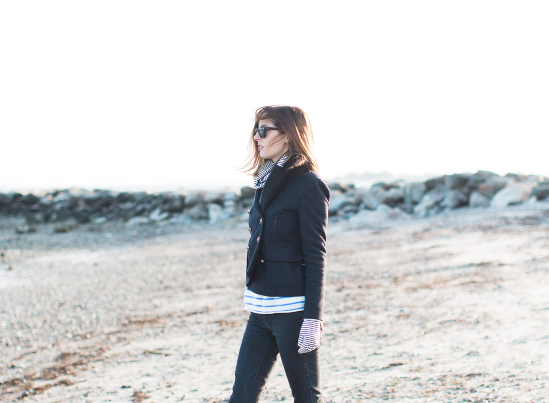 Eva Amurri Martino walks on Compo Beach in Connecticut in the winter time, wearing a navy blue peacoat and black wayfarers