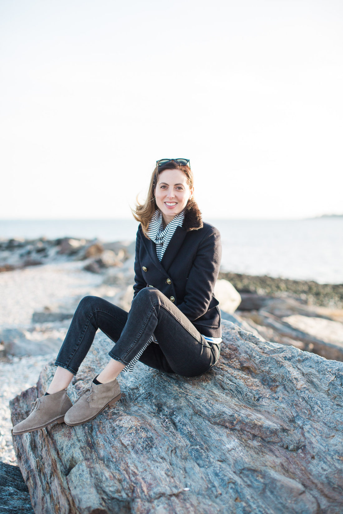 Eva Amurri Martino sits on a boulder on Compo Beach in Connecticut with the Long Island Sound behind her