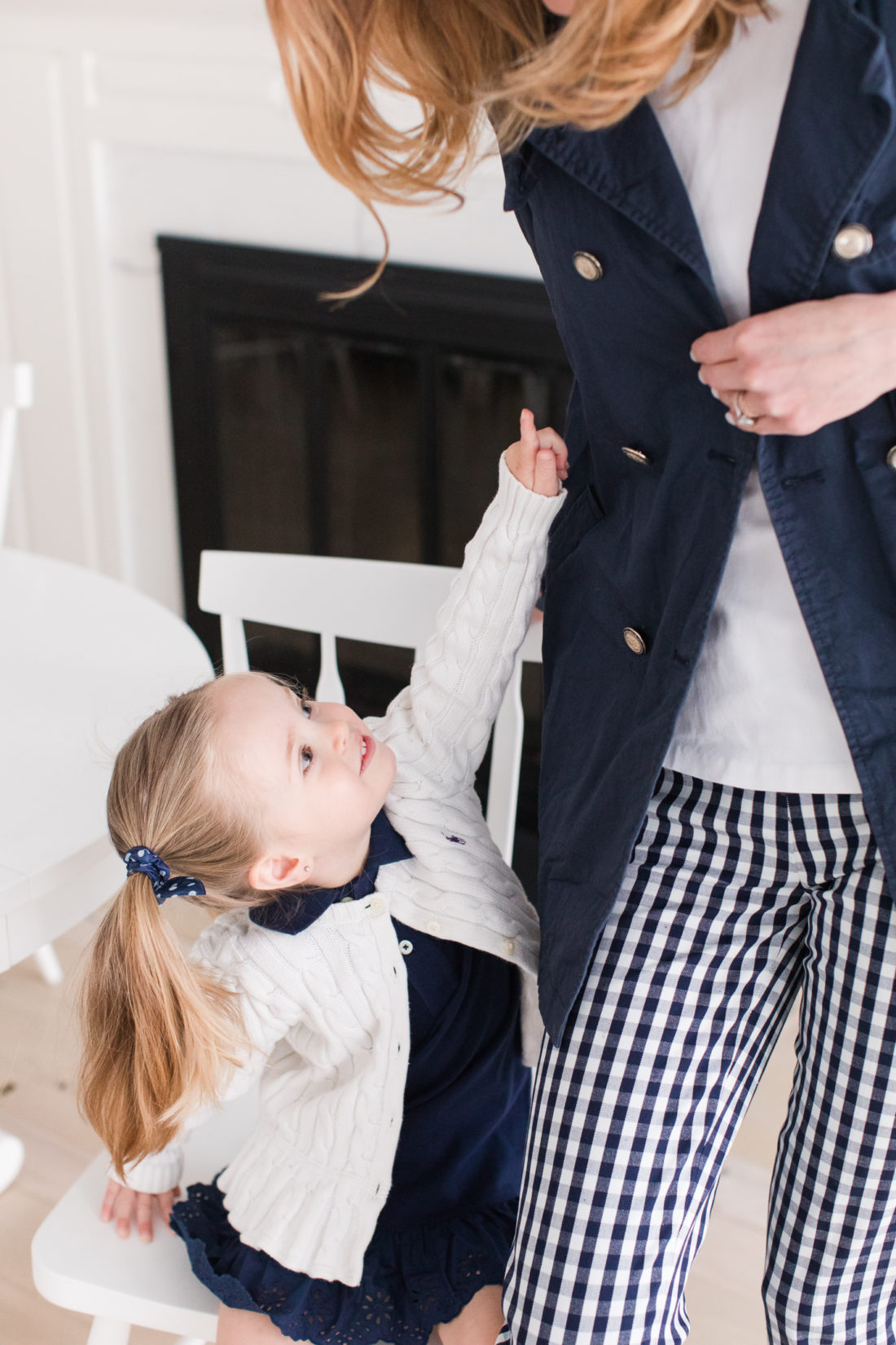 Marlowe Martino points to the buttons on her Mom's navy blue trenchcoat