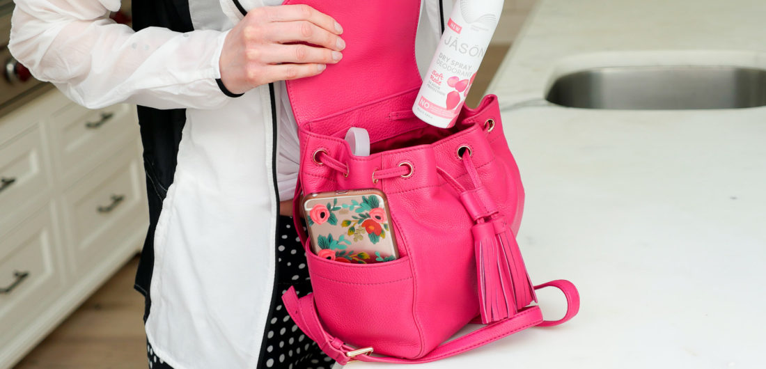 Eva Amurri Martino places a can of JASON dry spray deodorant in to her pink Tory Burch backpack