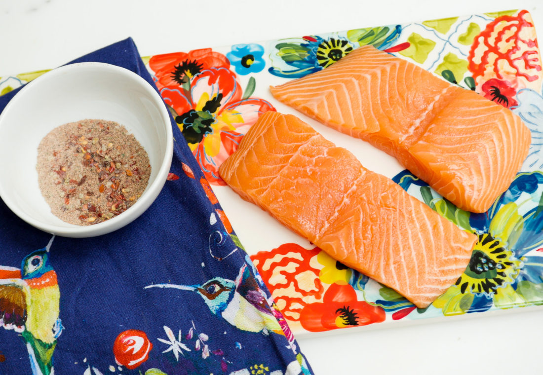 Raw salmon sits next to a bowl of Mexican Spice rub for Eva Amurri Martino's healthy salmon bowls