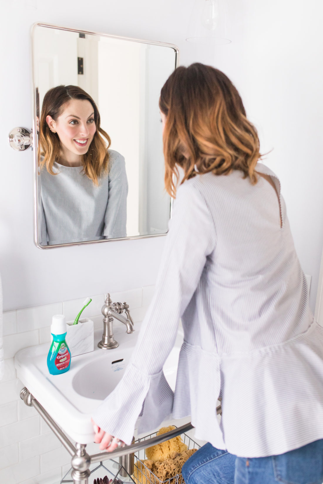 Eva Amurri Martino smiles to check out her clean teeth in the mirror