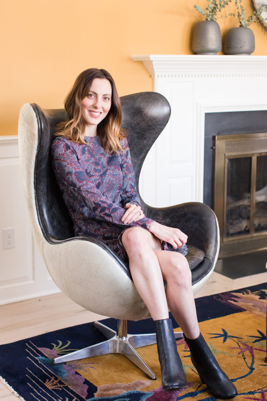 Eva Amurri Martino sits in a leather wingback chair in front of the fireplace in her formal living room