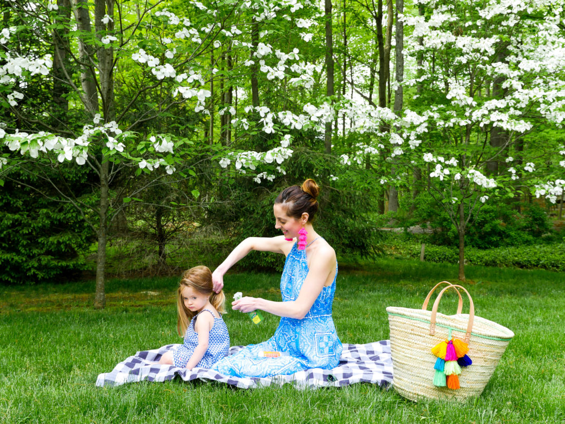 Eva Amurri Martino sits on a picnic blanket with daughter Marlowe and applies bug spray