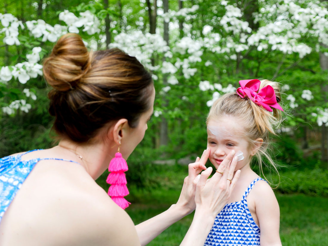 Marlowe Martino gets sunscreen applied to her face