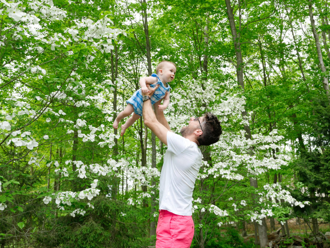 Kyle Martino lifts son Major in to the air, surrounded by greenery