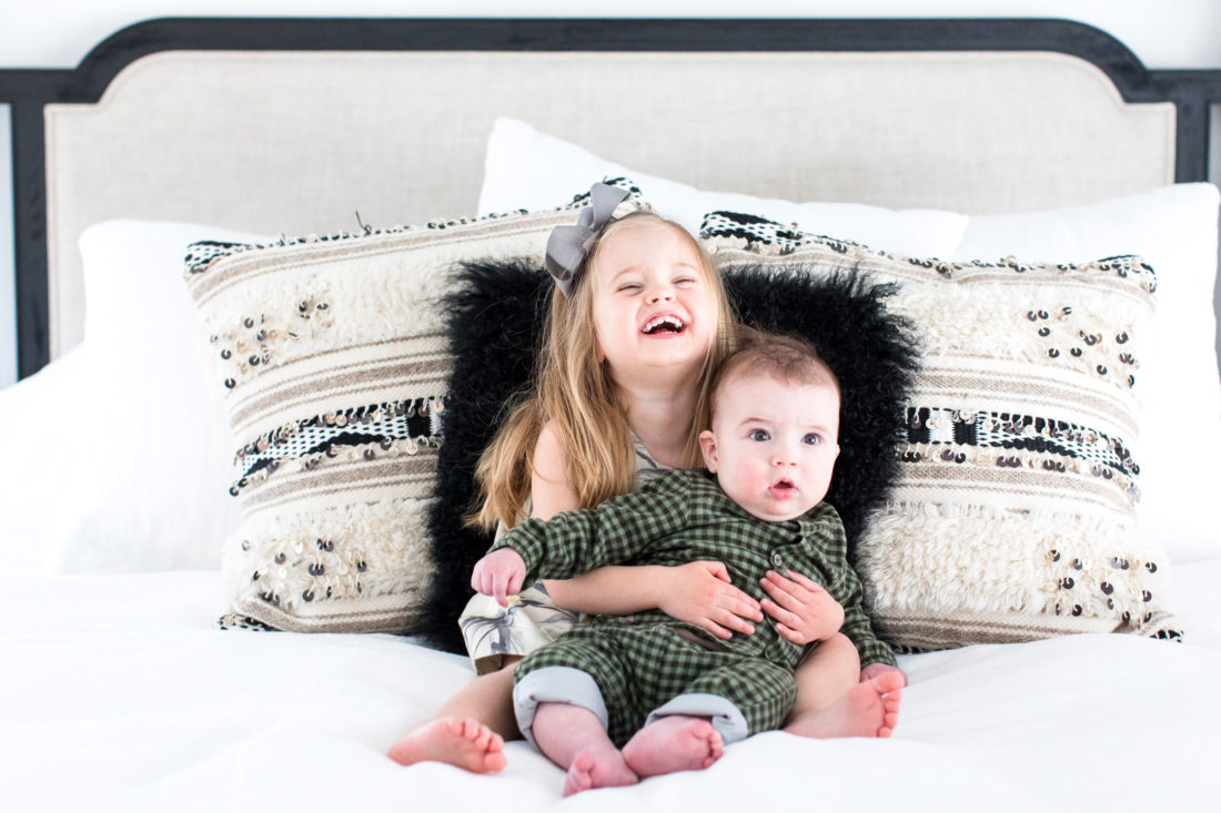 Marlowe Martino holds her little brother Major in her lap on her parents' bed