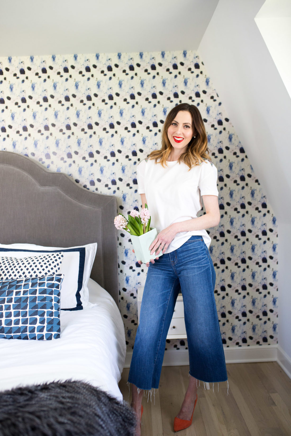 Eva Amurri Martino holds a vase of flowers in her newly updated guest bedroom at home in connectiut