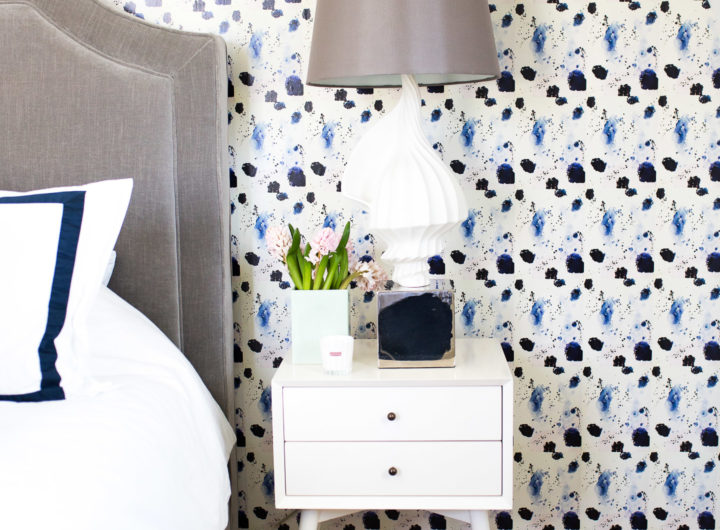 Eva Amurri Martino shows off her guest room revamp, featuring crisp navy and white sheets, midcentury modern bedside tables, a jonathan adler lamp, and kerri rosenthal wallpaper.