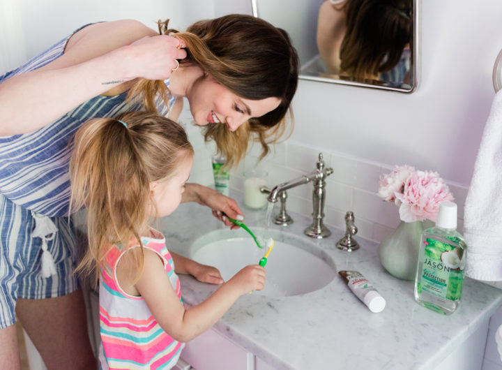 Eva Amurri Martino wears a blue and white striped romper and brushes her teeth with two year old daughter, Marlowe, in the bathroom of their Connecticut home