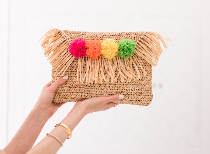 Eva Amurri Martino holds up a multicolored DIY pom pom straw clutch