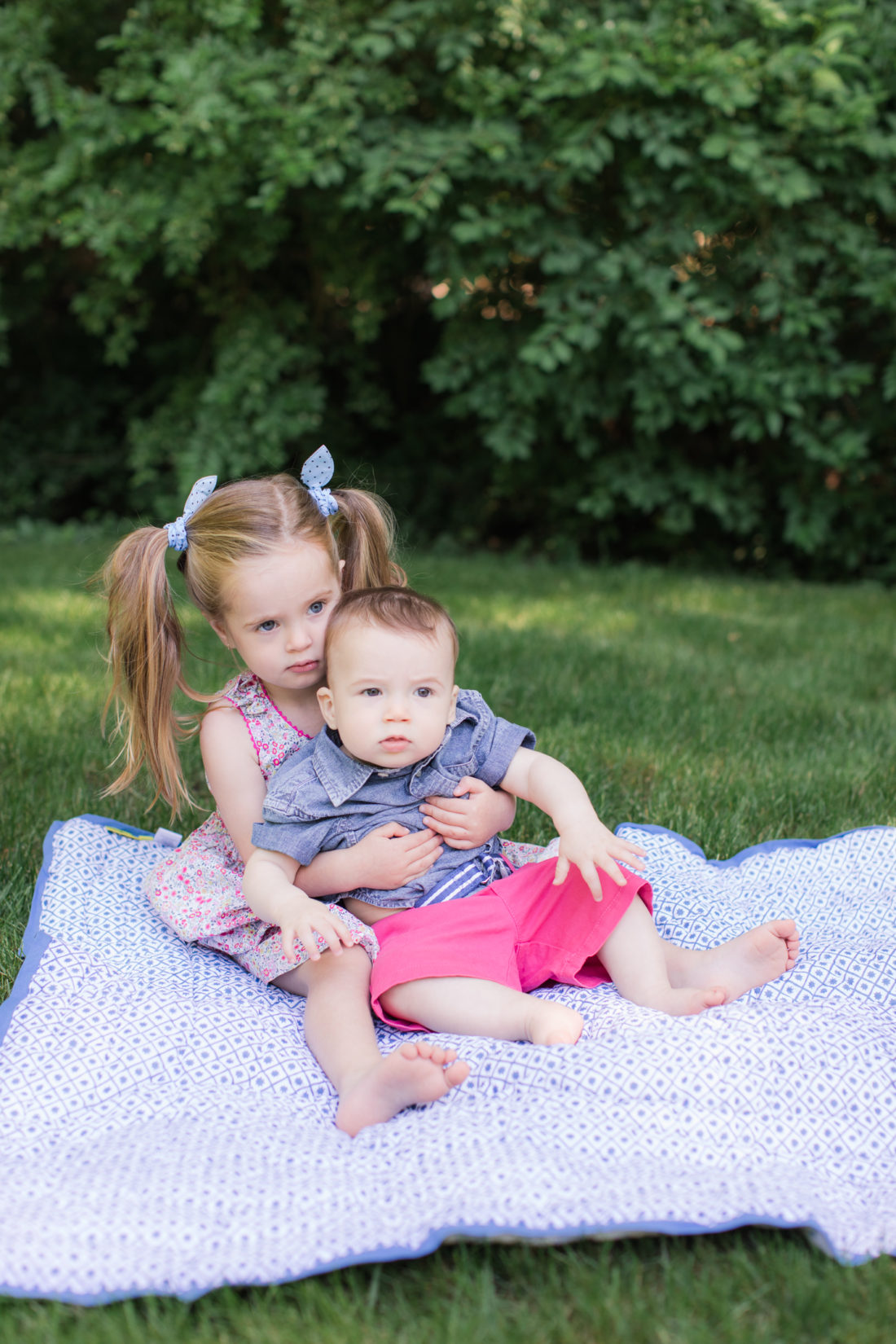Marlowe Martino holds eight month old brother Major on a picnic blanket on the grass outside her Connecticut home